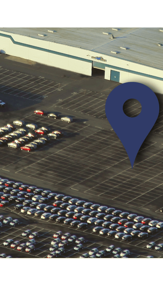 An overhead picture of a Auto Warehousing Company building showing a map pin in the parking lot.